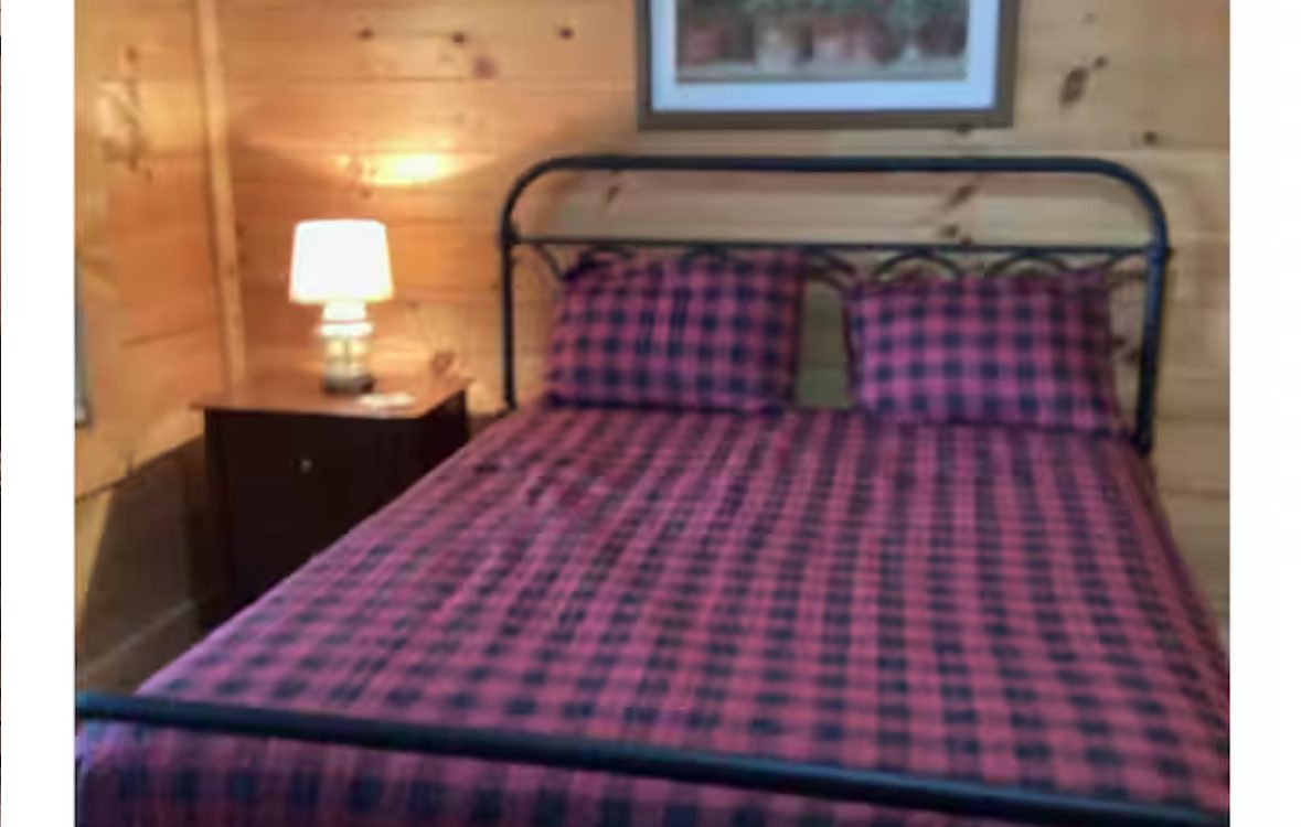 Queen bedroom with red plaid bedding and iron frame