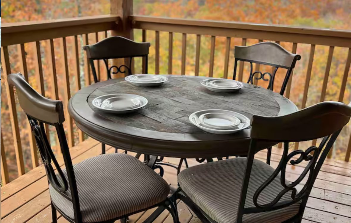 Round table set for four on the deck over fall color