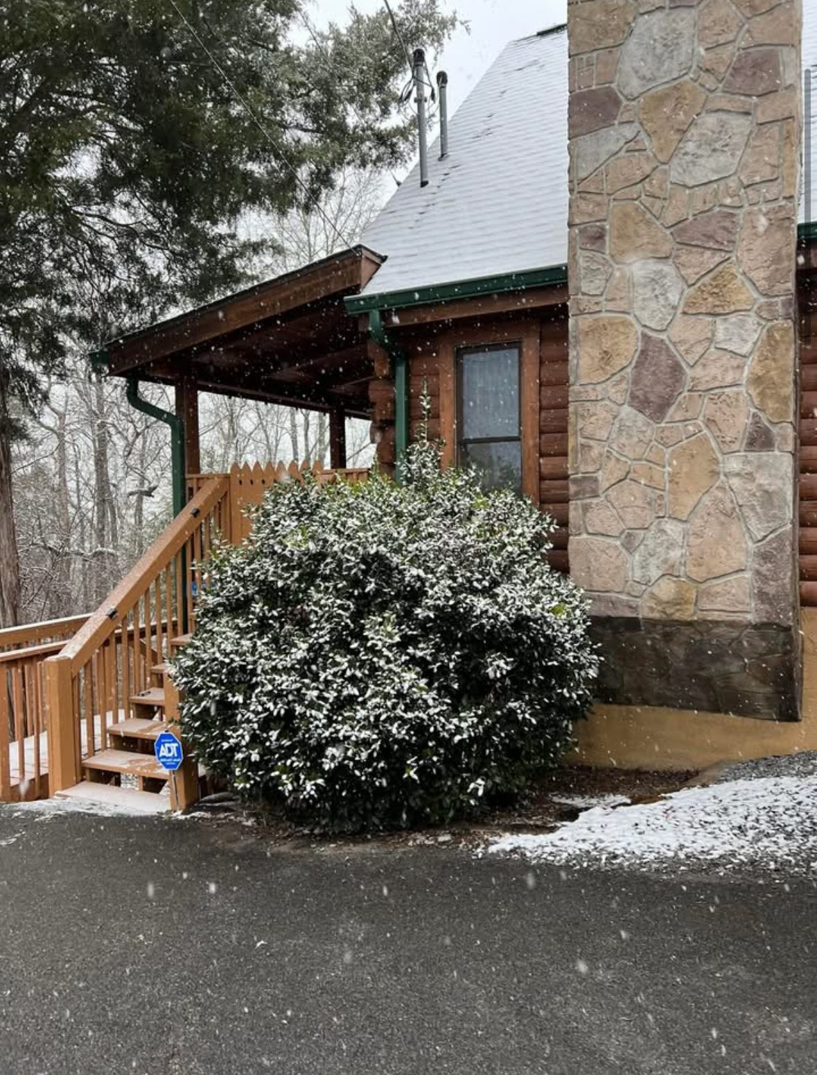 Cabin entrance and stone chimney in falling snow
